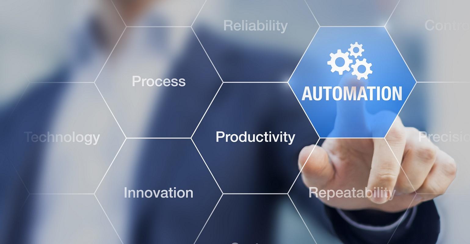 Businessman touching a digital interface with the word "automation" surrounded by related terms like productivity, reliability, innovation, and it operations.