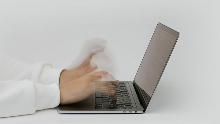 A person typing on a laptop computer while using code security scanning tools.