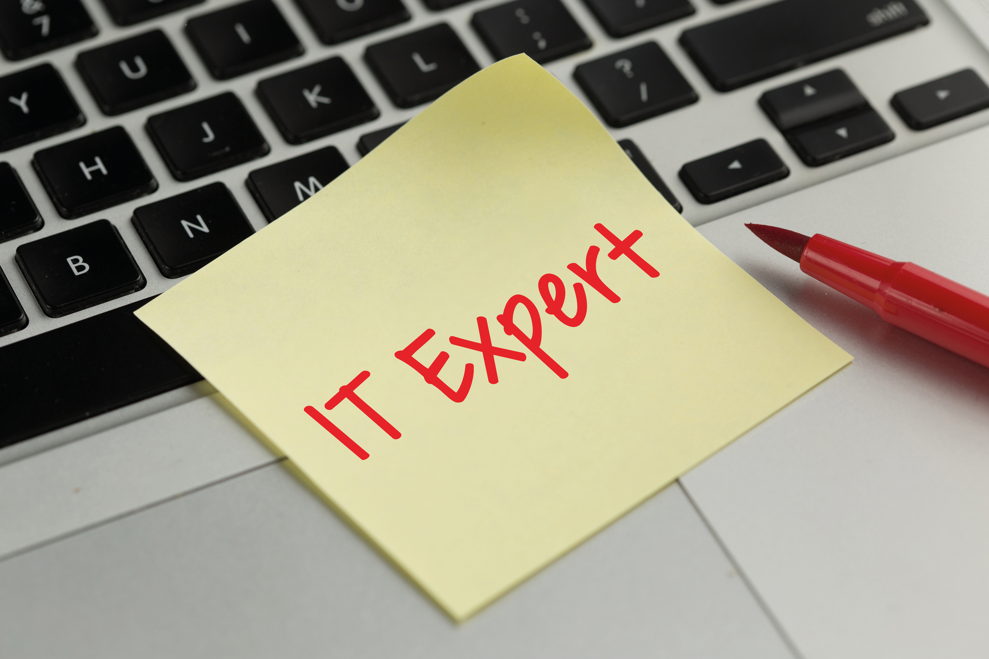 An IT expert's sticky note on a keyboard, symbolizing the concept of what are managed IT services, and the hands-on approach taken by professionals in this field.