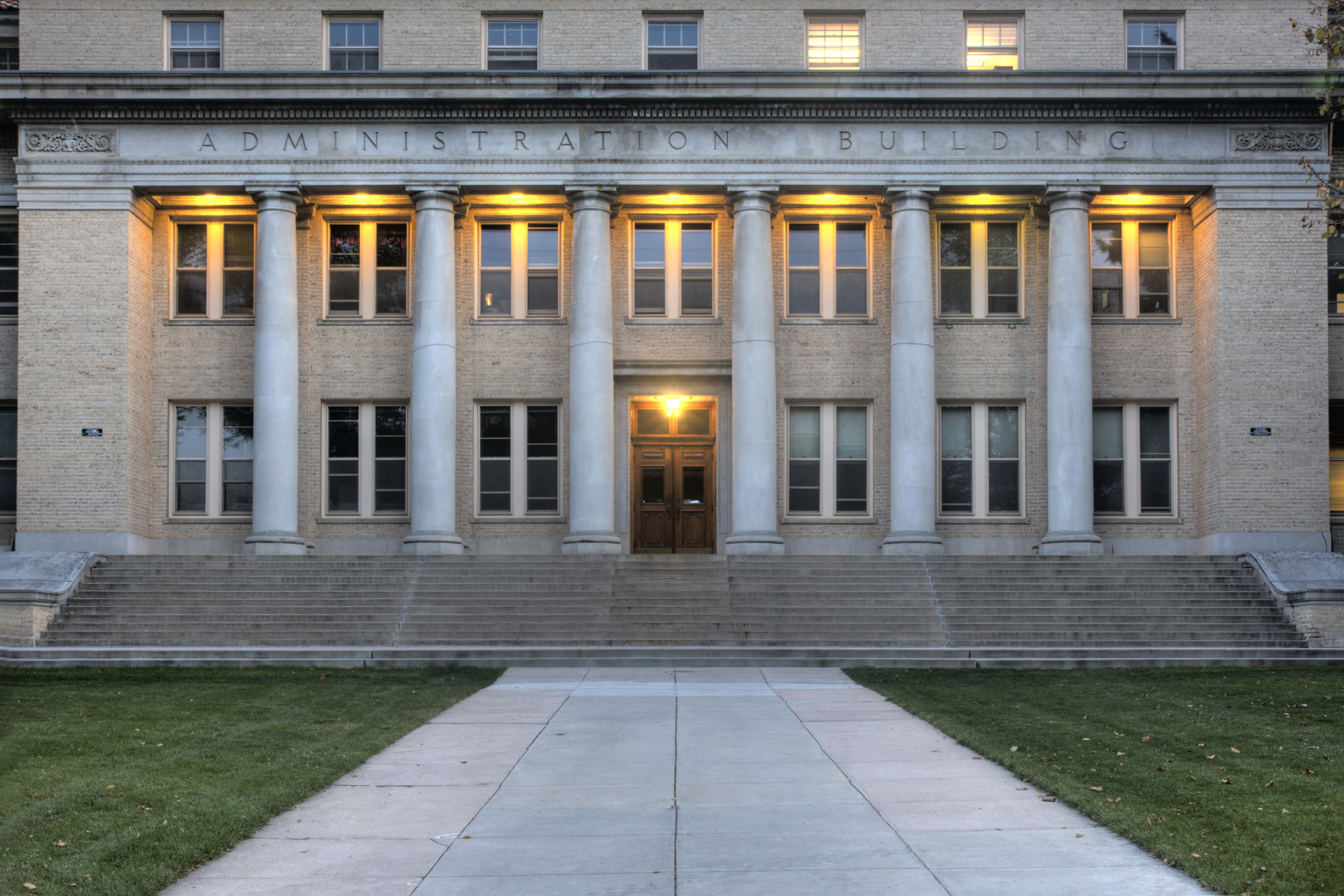 facade of administration building of Colorado State University, Fort Collins with some lights on at dusk