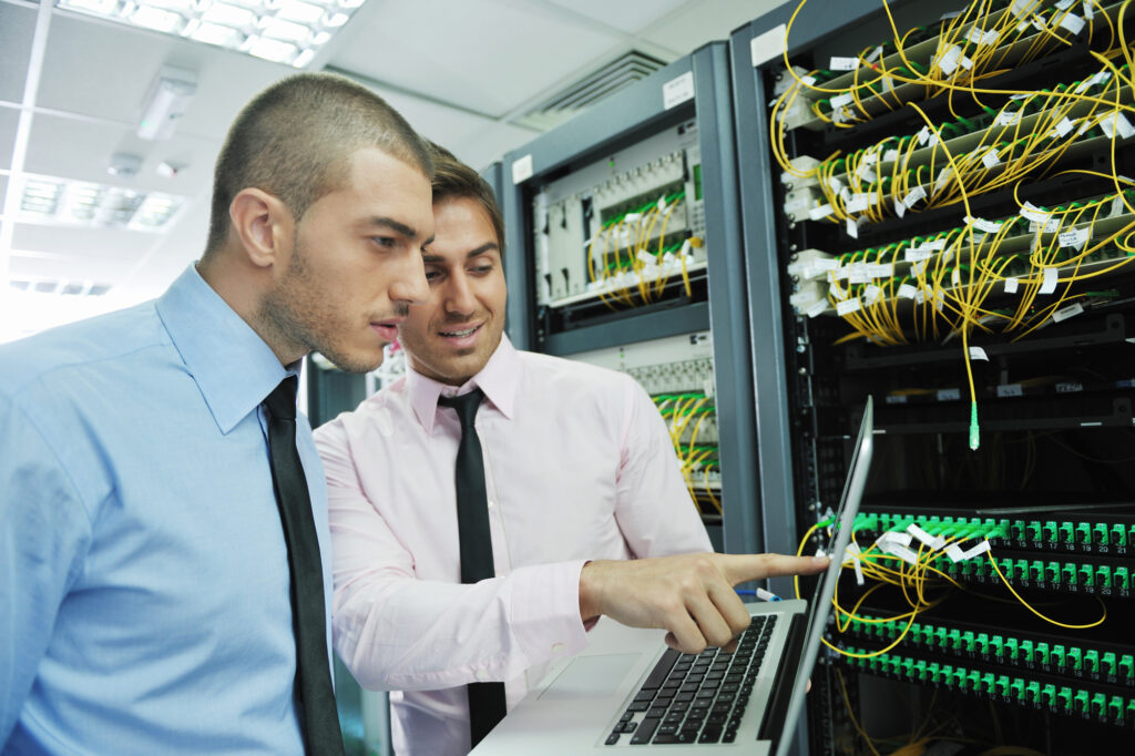IT Support in action: Engineers working in a network server room, exemplifying what IT support is all about.