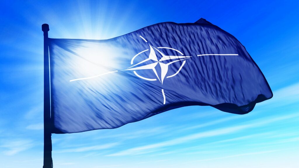 NATO flag flies in the sky during intense probe into alleged data heist by SiegedSec hackers.
