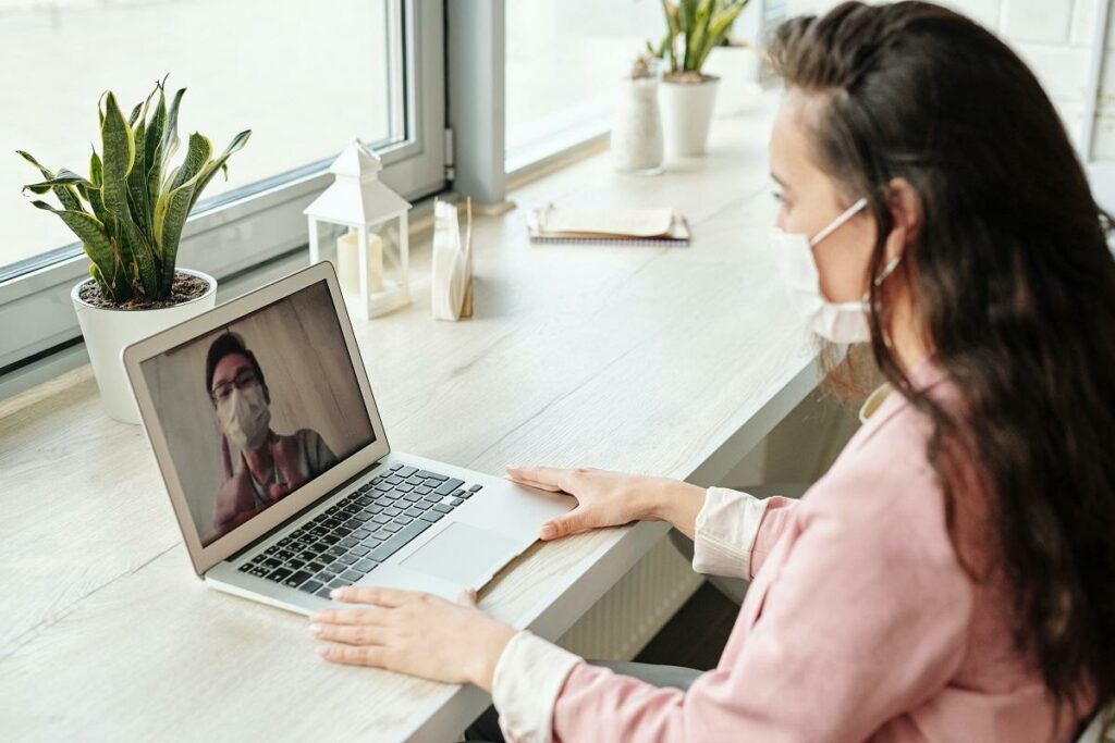 A woman is using a laptop to make a video call.